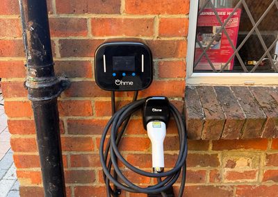 Ohme EV charger installed on a brick wall